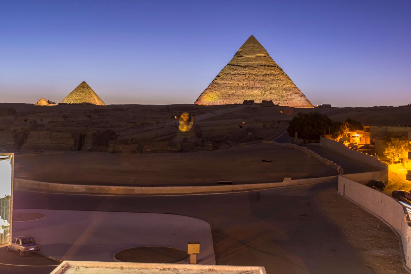 Camels resting before the pyramids at dusk